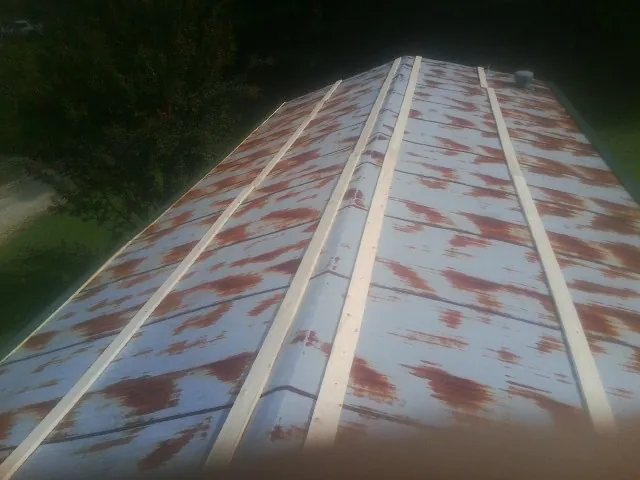 Rusted metal roof panels with new wood purlins before replacement — Storm Damage Roof Repair in Ridgway by Roofing Brothers