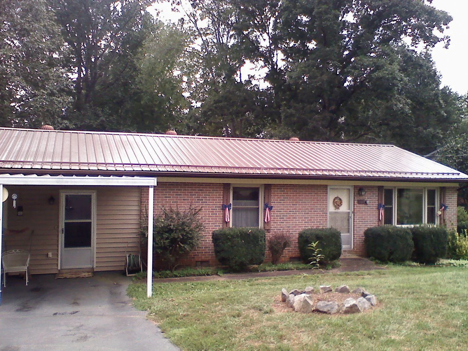 Bronze metal roof and carport on a brick ranch home — Roof Repair work by our crew in Ridgway
